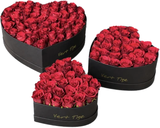Three black heart-shaped Vert Tige boxes filled with red roses